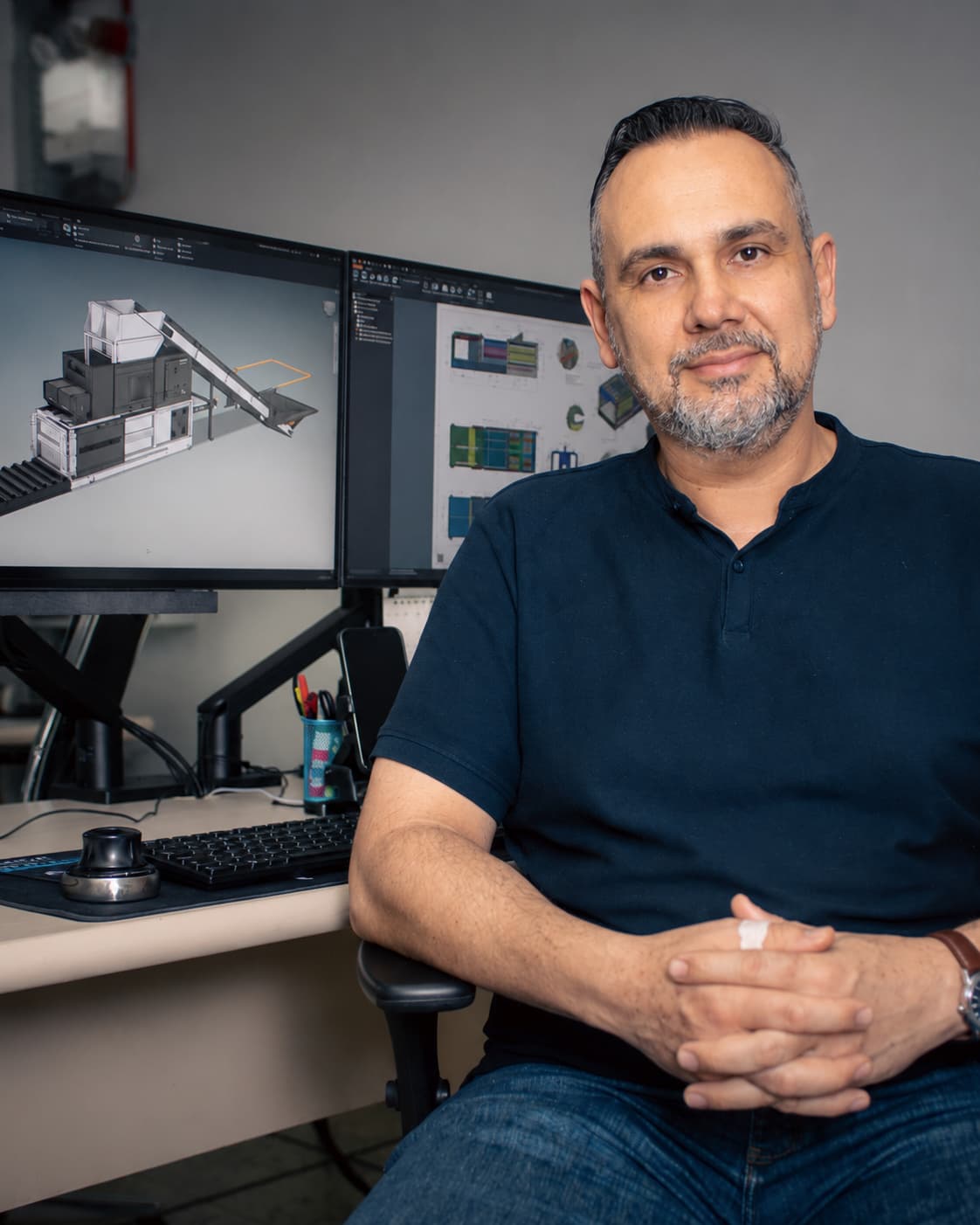Eder, coordenador de engenharia e projetos da Kubitz, à frente de dois monitores com o modelo 3D de uma planta de triagem